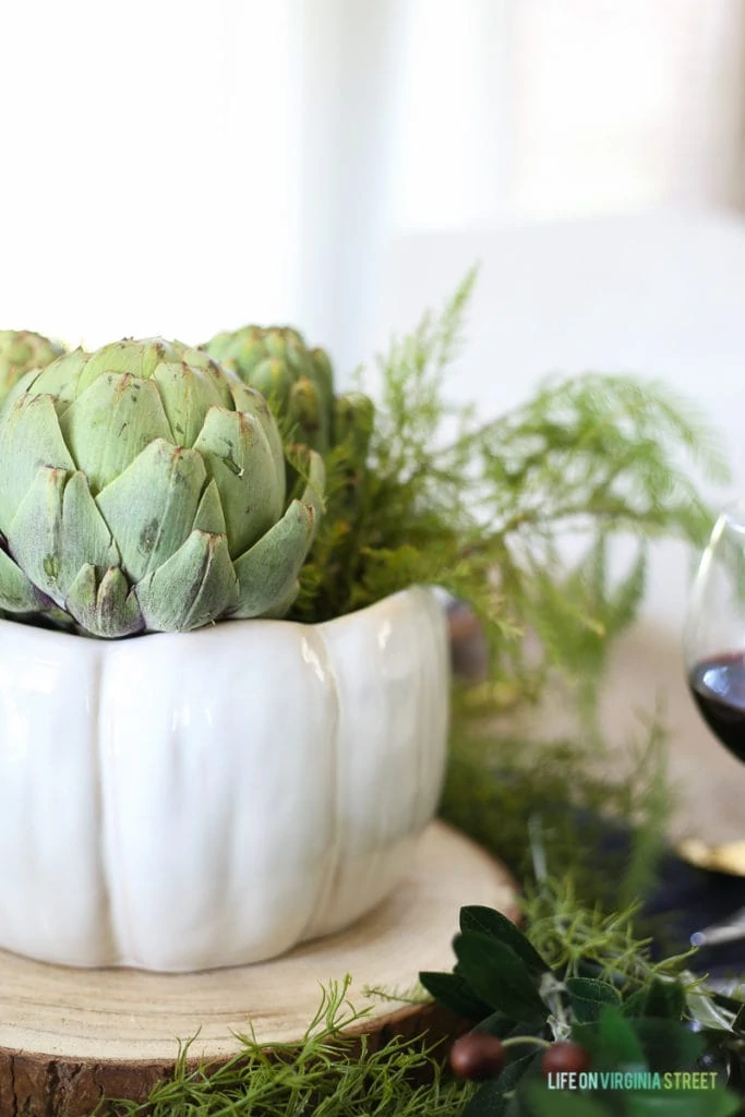 An artichoke in a white vase as a centrepiece.