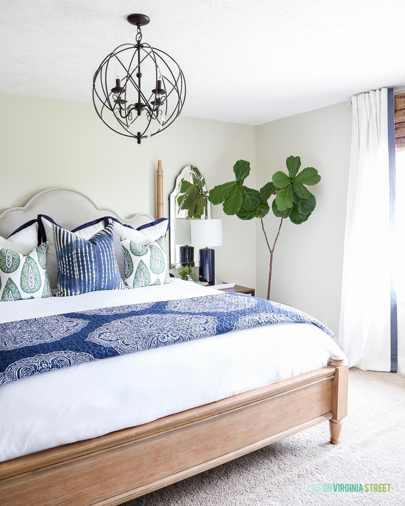 The mattress back and all the bedding with the newly painted neutral wall and chandelier over the bed.