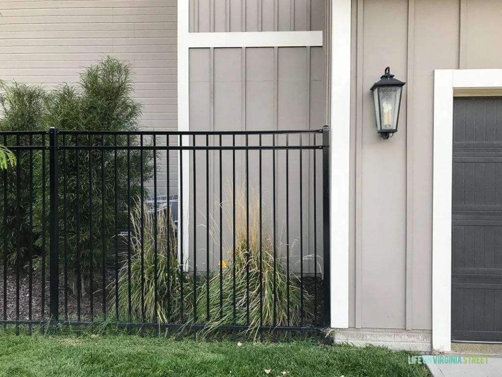 Black wrought iron fence beside garage door.