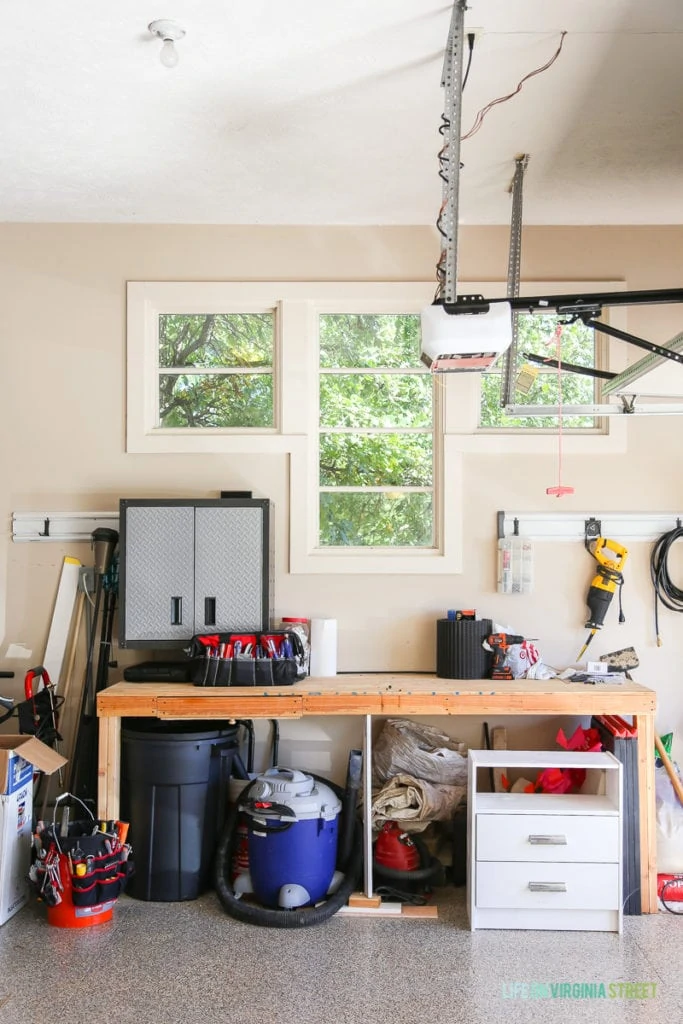 Wooden workbench in garage with tools on it.