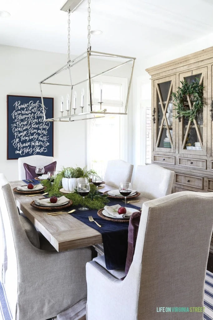 Navy blue table runner, and plums on the plate settings.