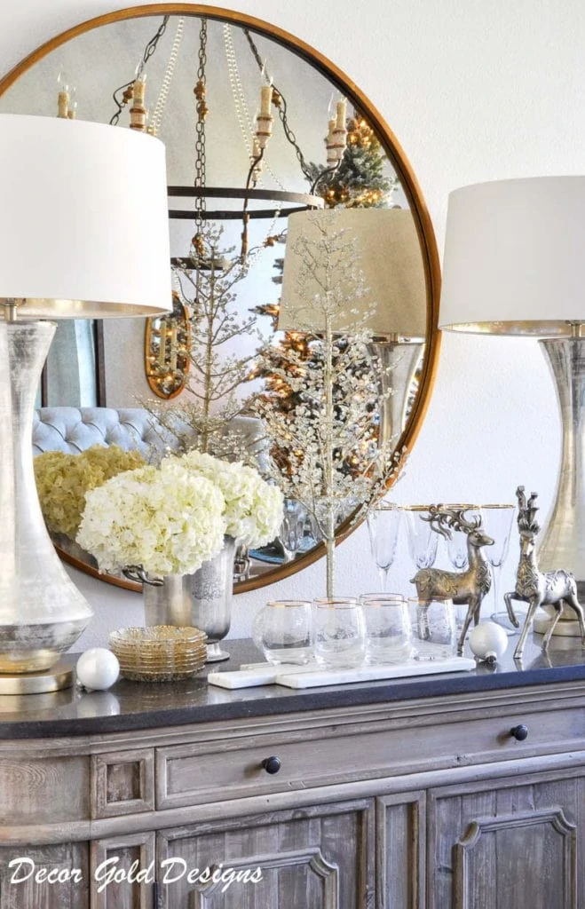 Gold mirror with white flowers and deer in living room.