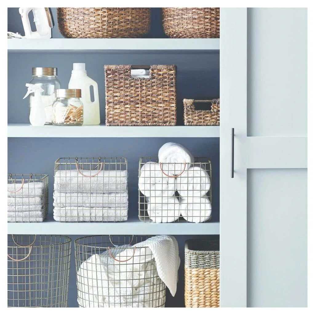 Linen closet with wicker baskets filled with towels.