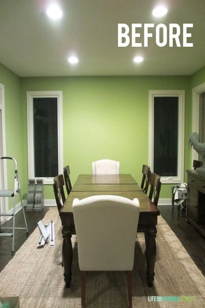The dining room painted lime green with a small table in the centre of the room.
