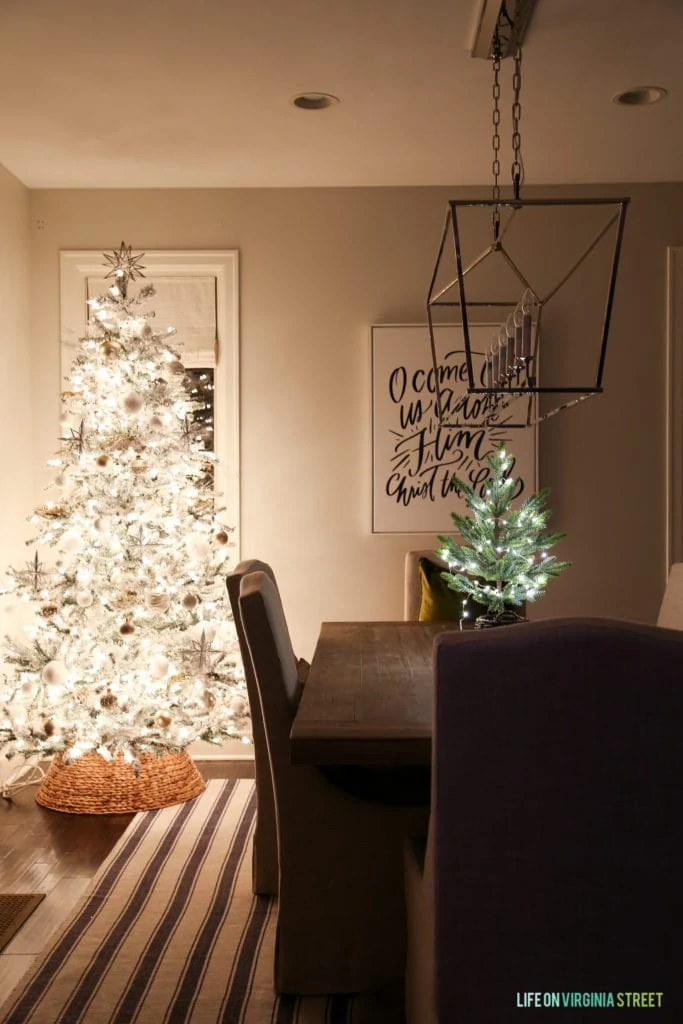 Dining room that has a white Christmas tree being the table.