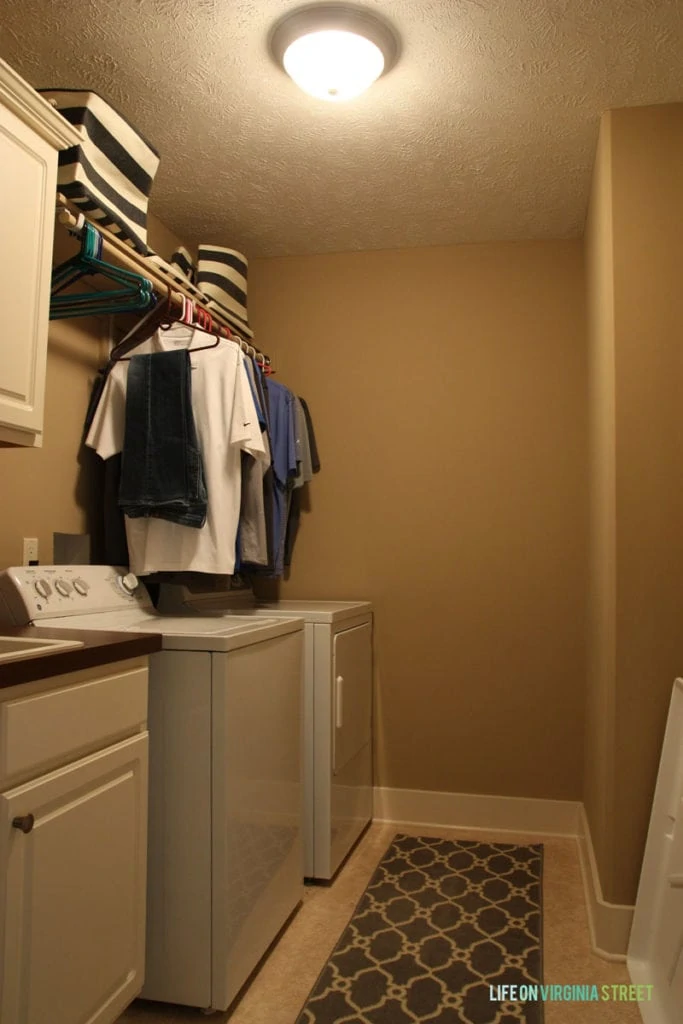 A dark beige laundry room with white washer and dryer.
