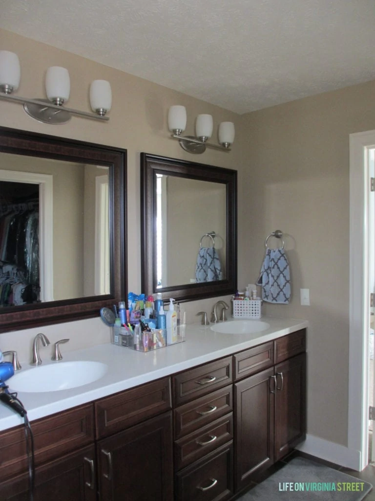 The master bathroom with a dark wood vanity and dark wooden mirrors.