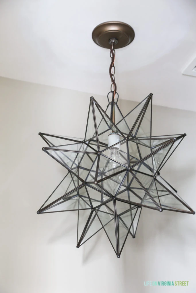 A star light fixture in a brushed metal hanging from the ceiling.