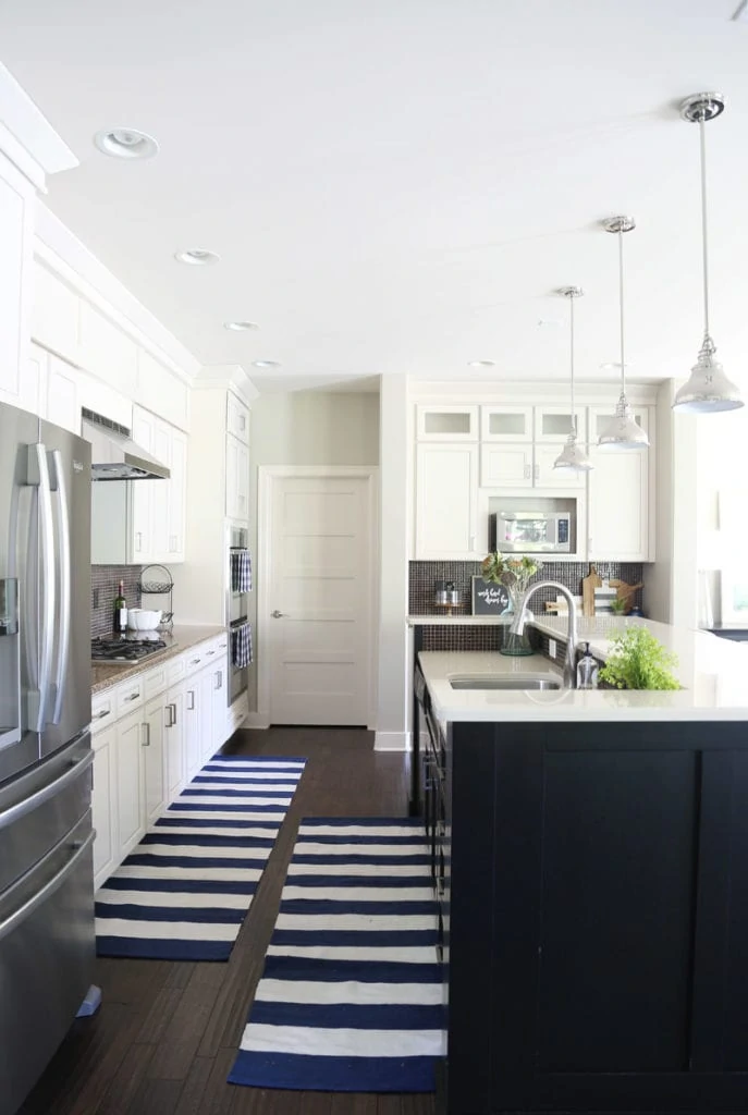 Blue and white rugs in the kitchen in front of the sink and the counter.