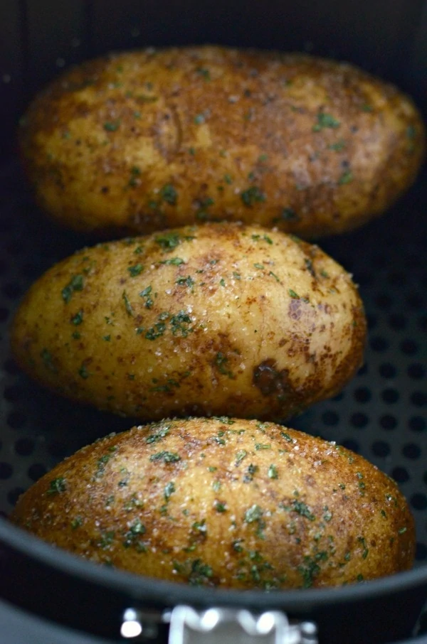 Air fried baked potatoes in a metal pan.