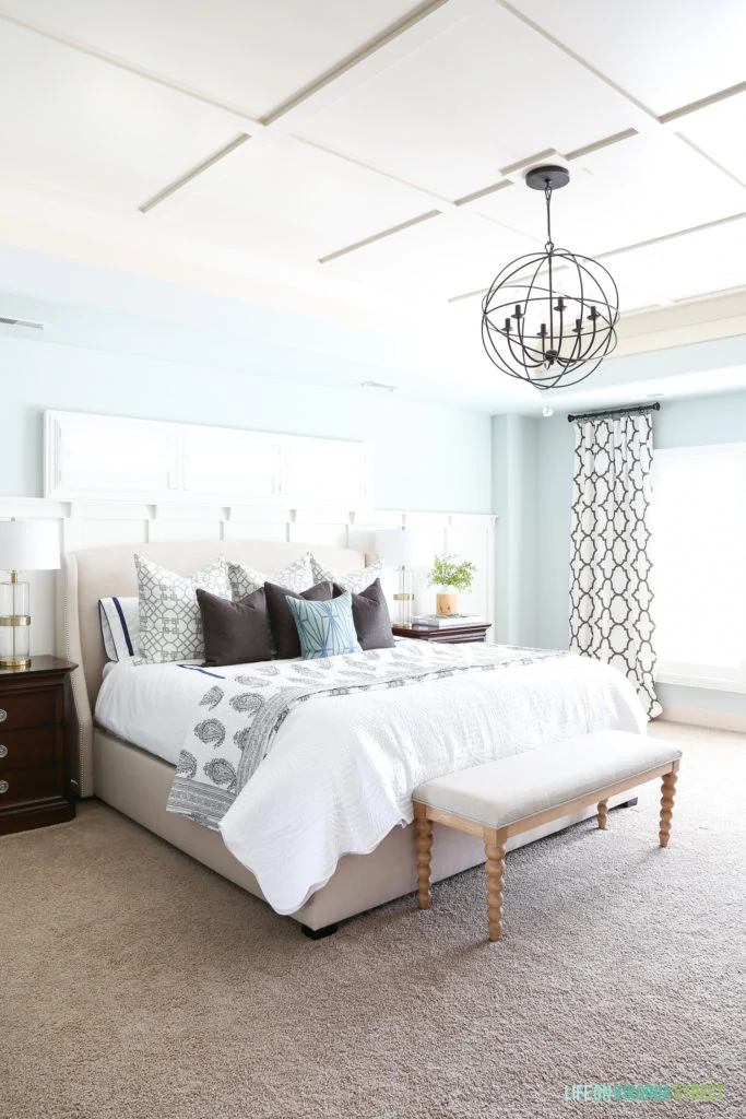 Bright master bedroom with board and batten ceiling and accent wall. Walls are painted Sherwin Williams Sea Salt. Beautiful white and brown paisley and scallop bedding from eBay. Trellis curtains accent blue and white bedding colors.