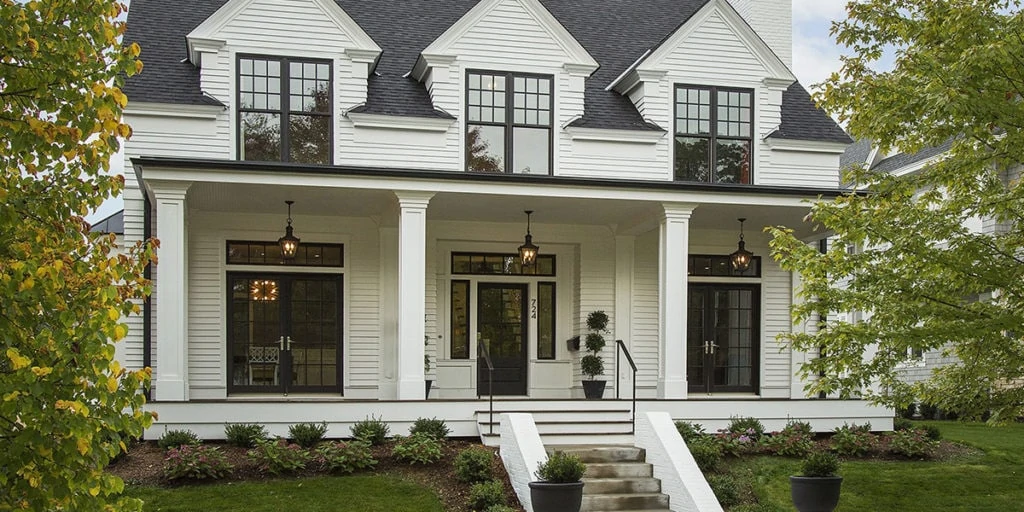 Benjamin Moore White Dove modern farmhouse with black window trim and front door.