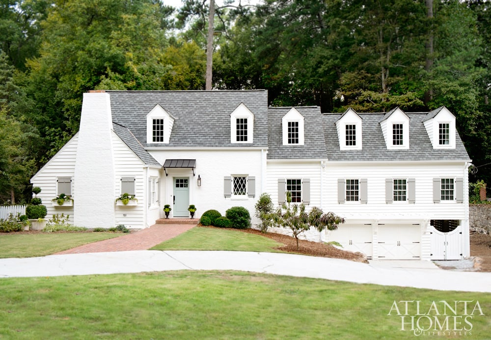 Dit prachtige huis is geschilderd met Sherwin Williams Alabaster, een van de beste witte buitenverfkleuren voor je huis. De luiken zijn geschilderd Sherwin Williams Pavestone, een lichte warme grijze kleur.