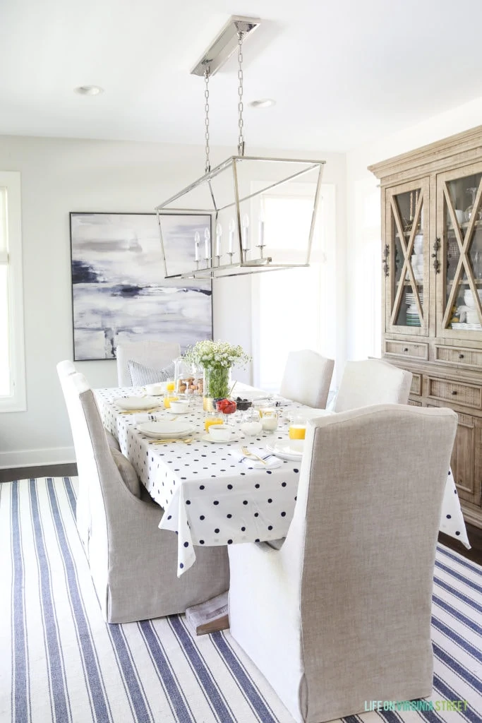 A blue and white striped rug and a dotted tablecloth in the dining room.