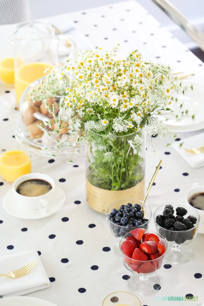 Baby's breath, daisy's, and berries on the table.