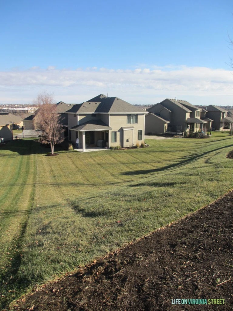 Light brown houses in a row with grass.