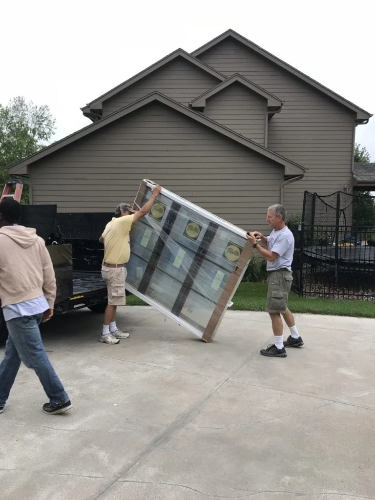 Two delivery men bringing in part of the kitchen packages.