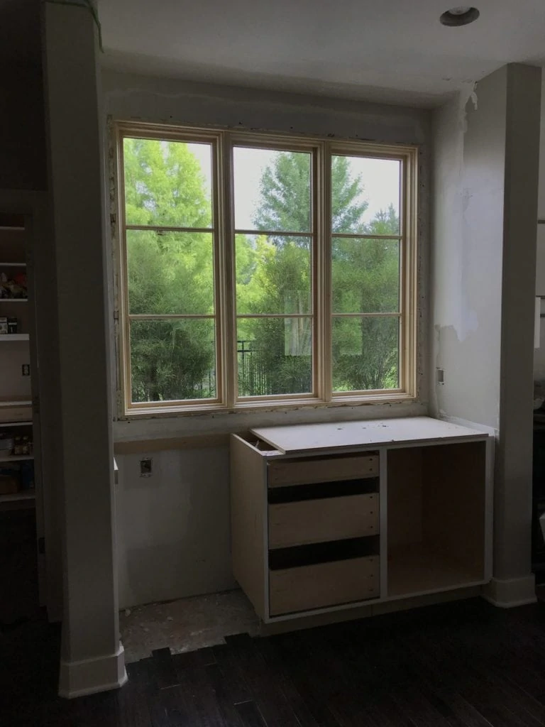 A cabinet being built underneath the new window in the kitchen.