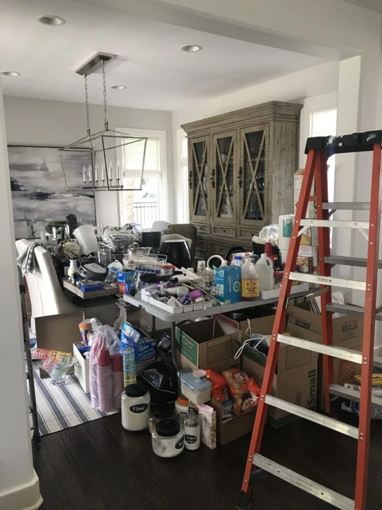 The dining room of the house filled with kitchen items being displaced from the demo.