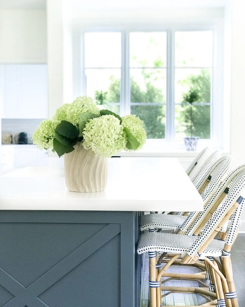 White kitchen with Benjamin Moore Providence Blue island and Serena & Lily bistro counter stools.