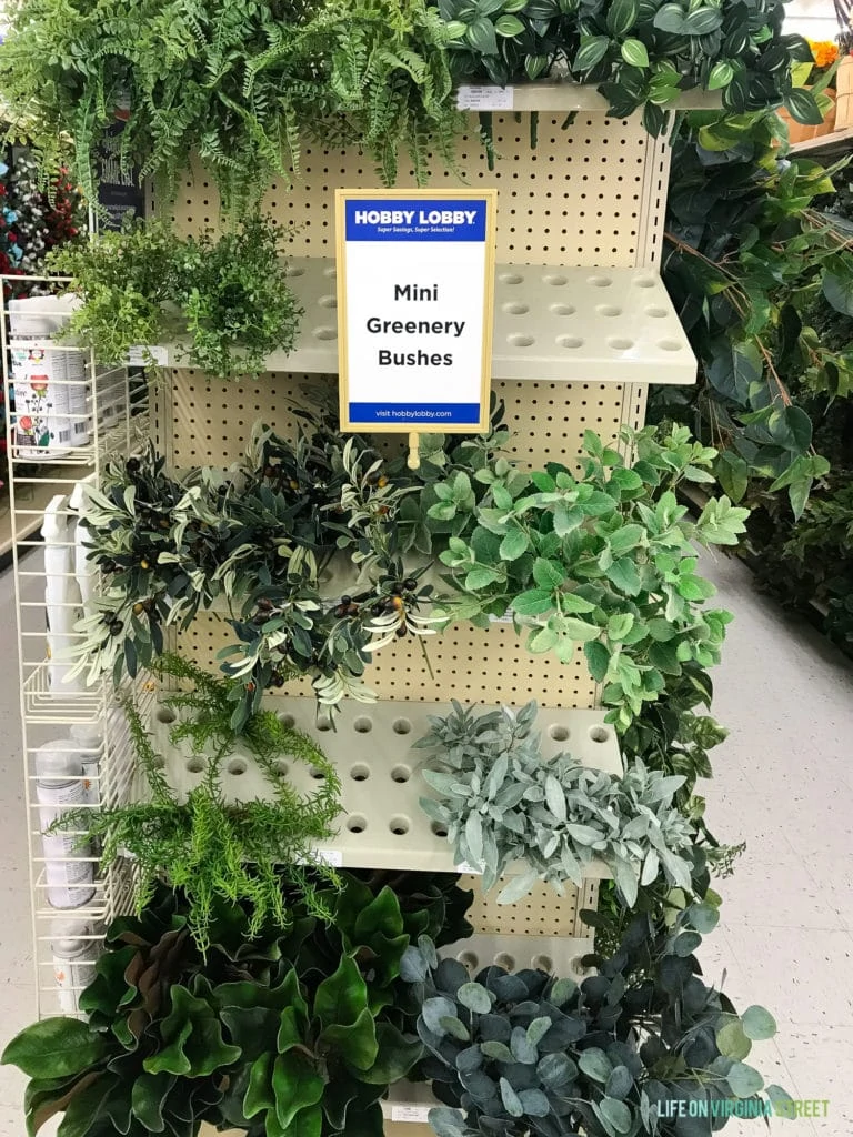 Faux green plants on the shelves in a store.