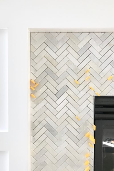 Carrara marble herringbone tile on a fireplace surround.