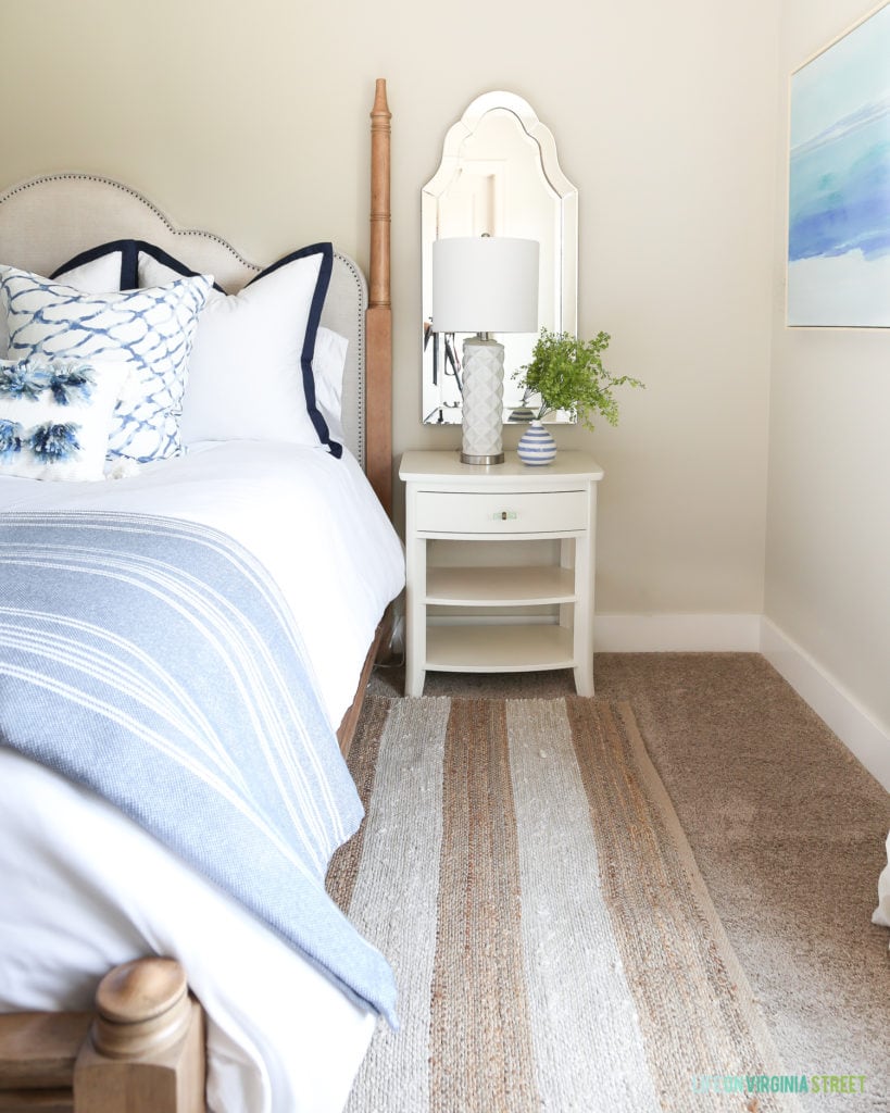 A simple white nightstand updated with new hardware looks perfect in this beachy bedroom.