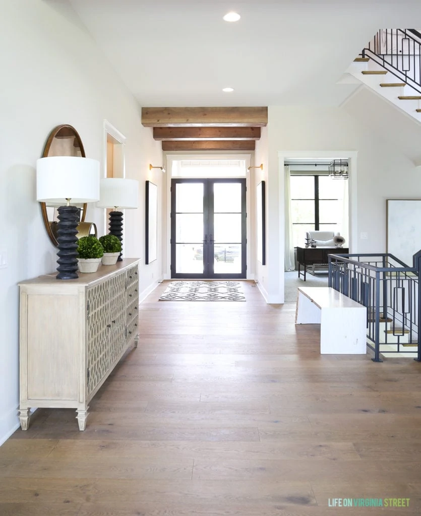 Gorgeous California Modern Farmhouse with white oak harwood floors, reclaimed wood beams, black doors and windows and metal staircase.