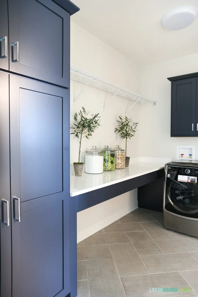 Laundry room with navy blue cabinets.
