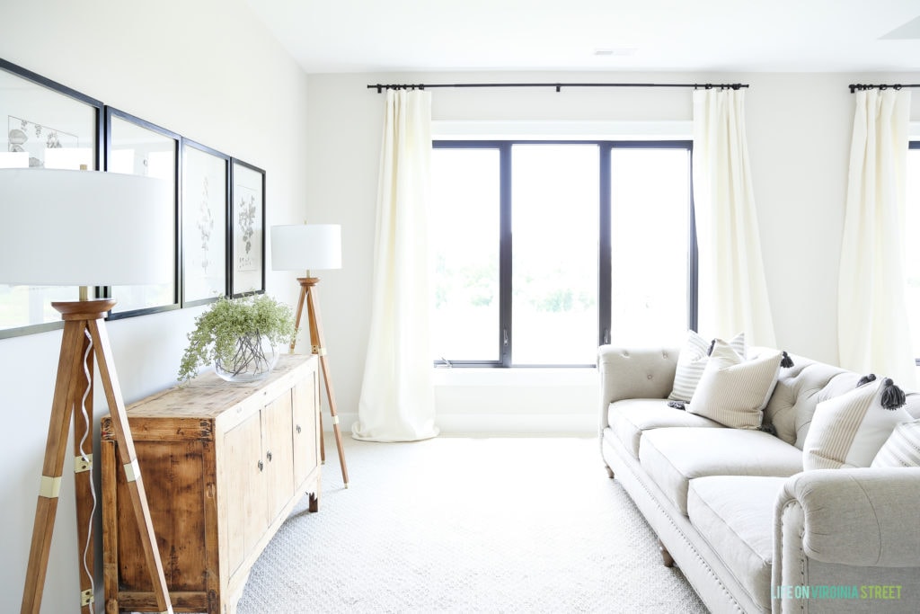 A large window with white curtains in the master bedroom.
