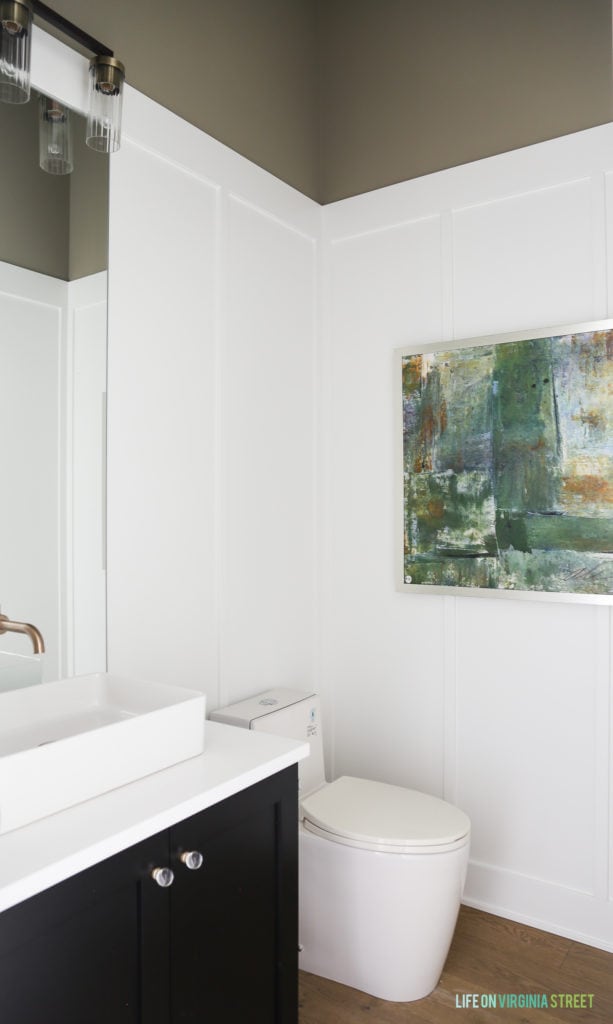 Board and batten carried into the bathroom with artwork on the wall.