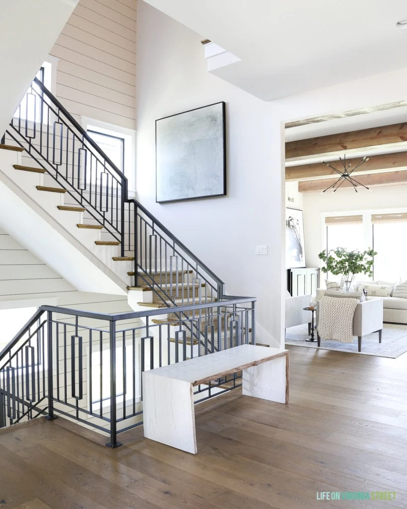 Metal staircase with a shiplap stair well and oversized abstract artwork.