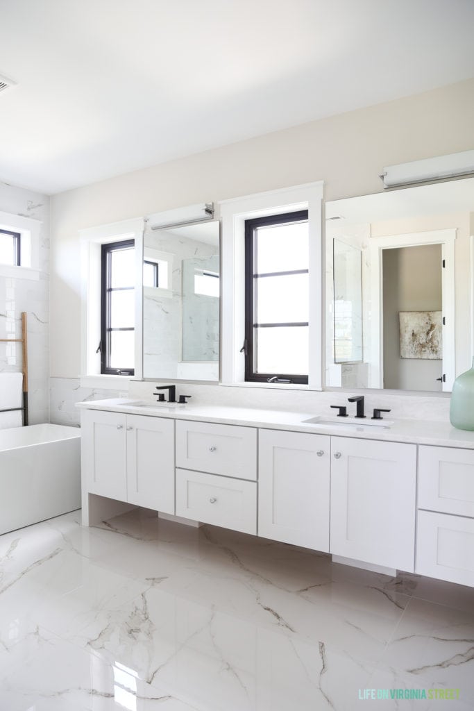 A white marble floor in master bedroom with white cabinets.