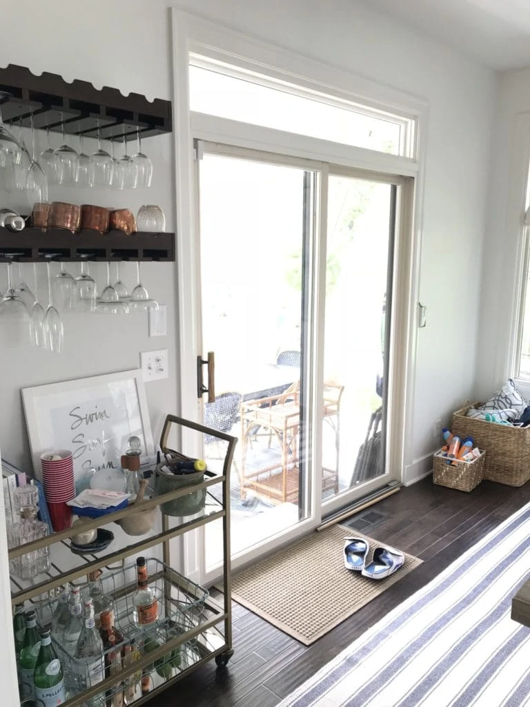 A bar cart beside a sliding glass door to the outside porch.