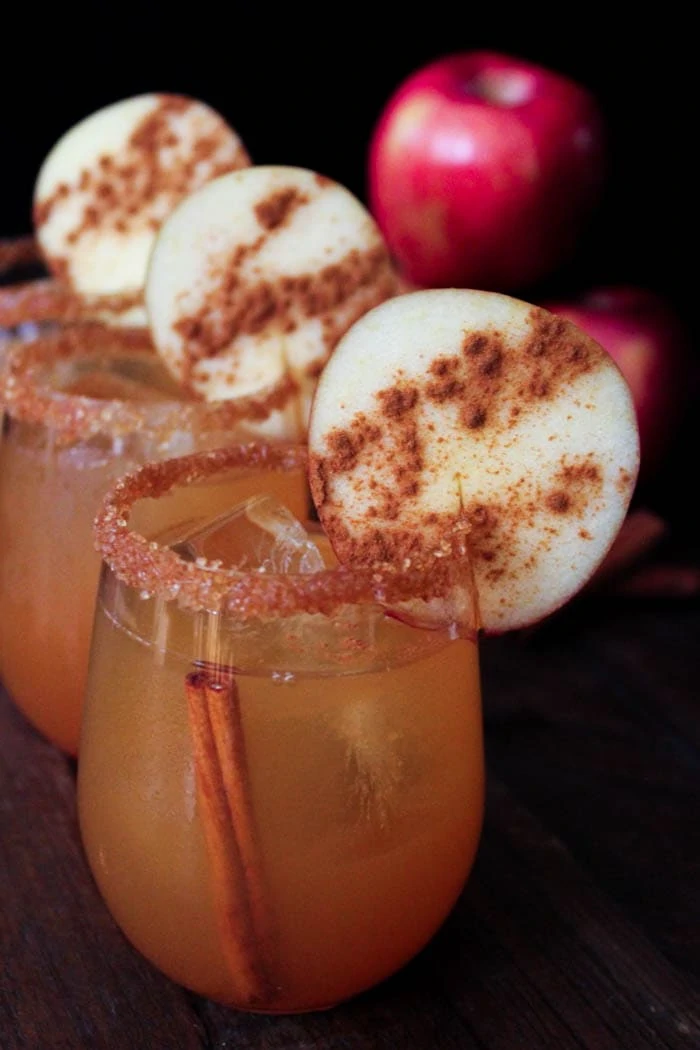 Spiced cider margaritas with an apple slice on rim and cinnamon sugar on the apple and rim.
