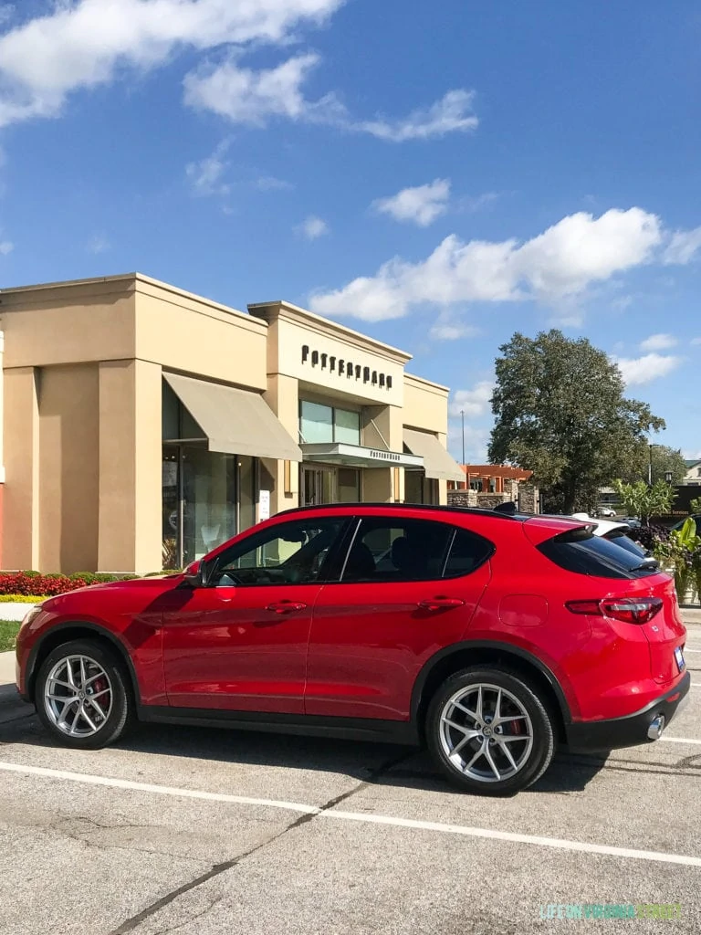 Red car parked in front of Pottery Barn.