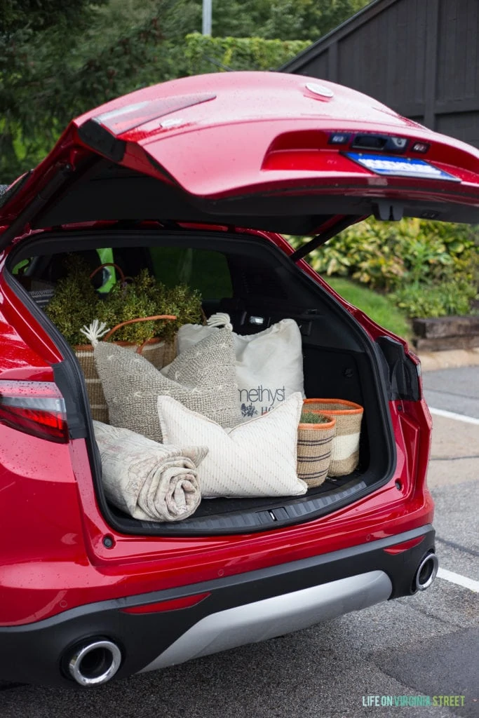 The hatchback open on the red car.