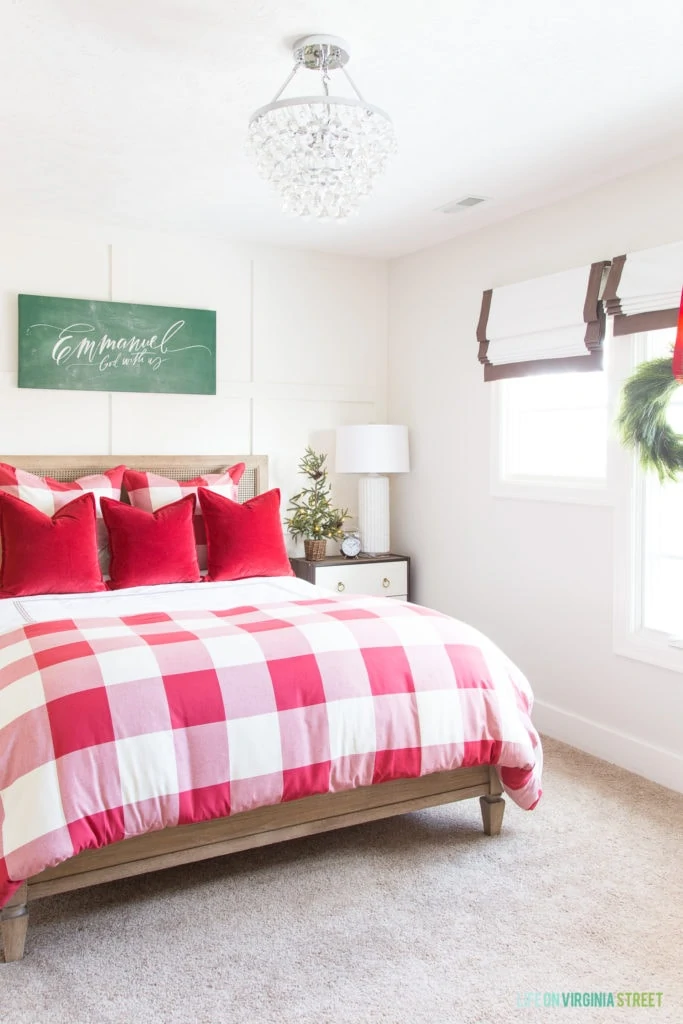 A cute red and white buffalo check bedroom that's perfect for Christmas! I love the Emmanuel chalkboard canvas over the bed and the wreath in the window.