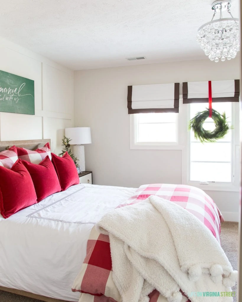 Red and white cozy winter guest bedroom. The buffalo check and red velvet pillows are on the bed.