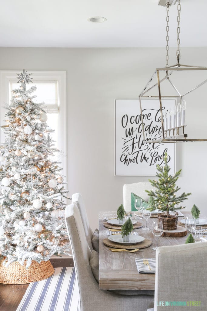 A beautiful, neutral dining room with a natural woven Christmas tree collar around a flocked tree!