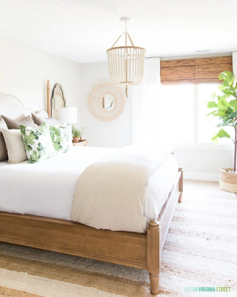 Beautiful green and neutral bedroom with a white bead chandelier.