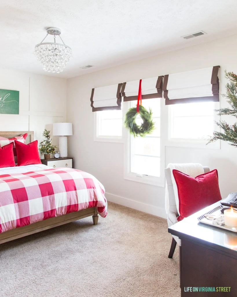 Green wreath hanging by the window in the decorated guest bedroom.