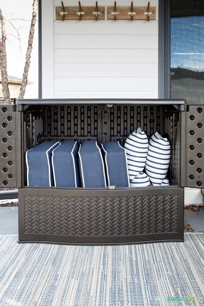 An outdoor storage cabinet with outdoor pillows in it.