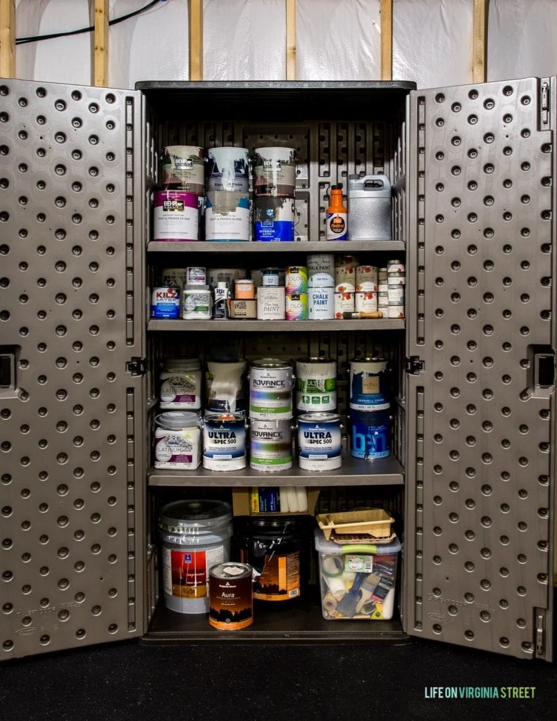 A storage cabinet filled with various sizes of paint cans.