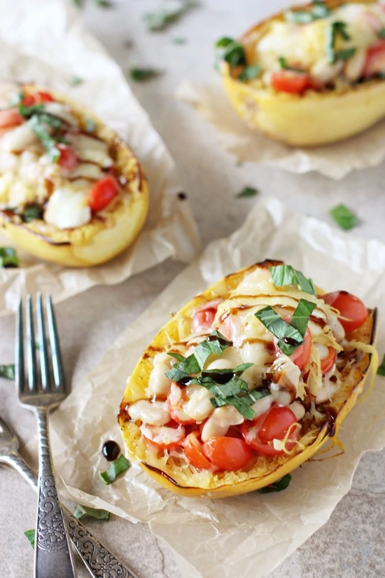 Caprese Stuffed Spaghetti Squash Recipe with a fork beside the squash.