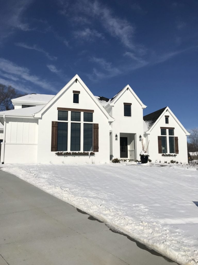 A white painted brick English Farmhouse painted Sherwin Williams Pure White.