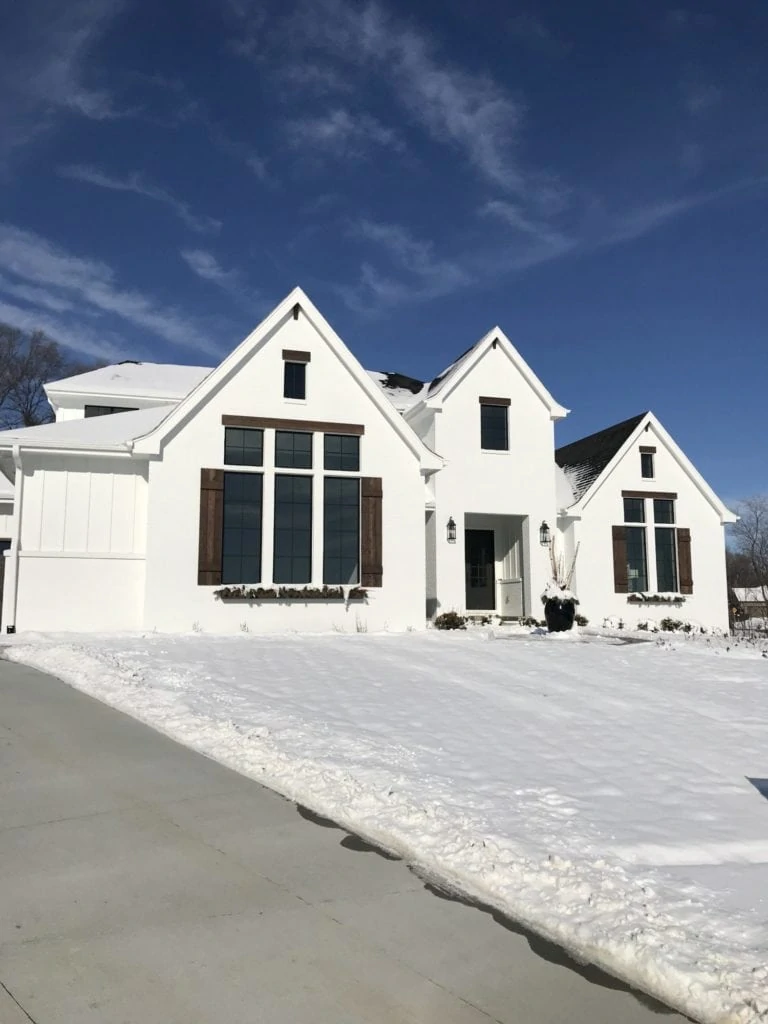 Painted white brick English farmhouse home tour. The white paint is Sherwin Williams Pure White with walnut stained shutters and Sherwin Williams Iron Ore front door and garage doors.