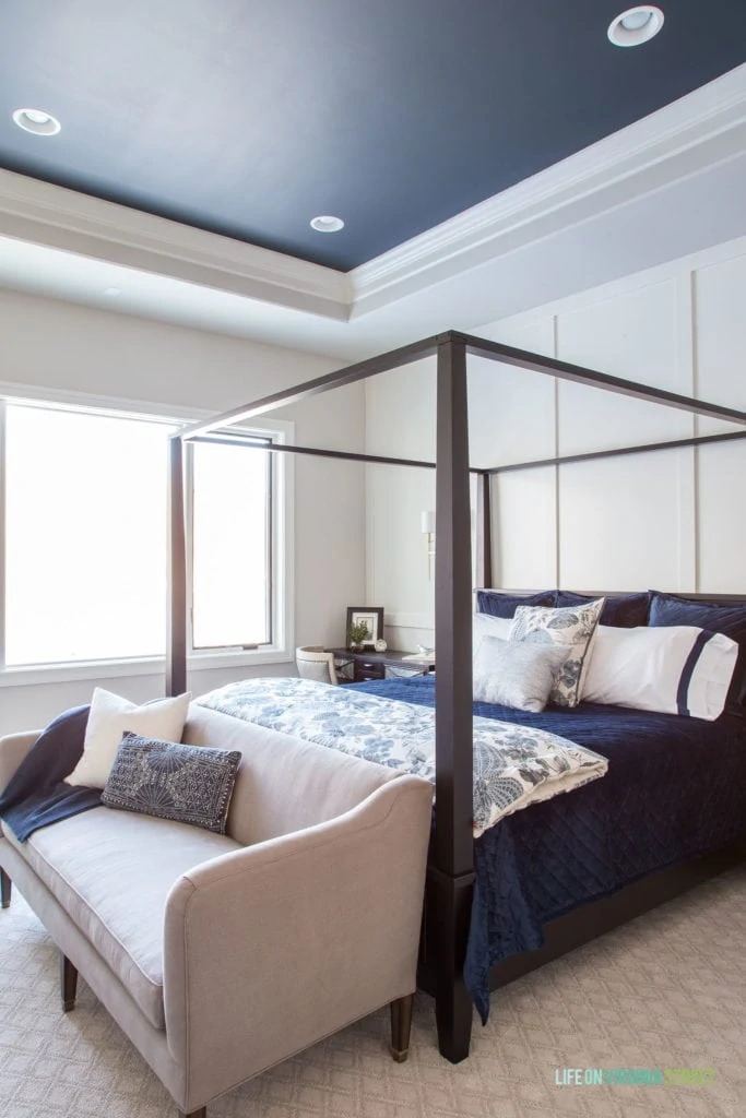 Master bedroom with white board and batten walls and a dark ceiling painted Benjamin Moore Midnight Blue.