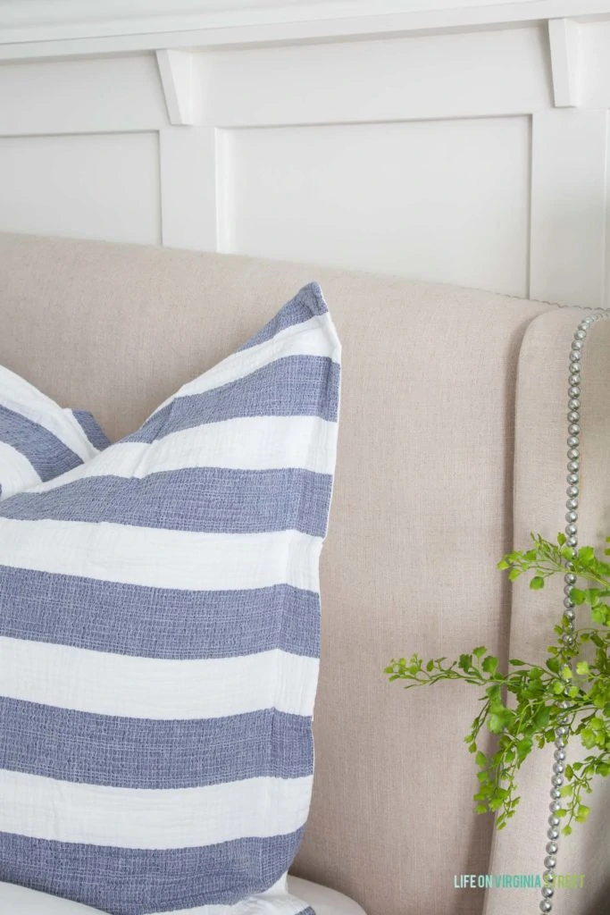 Up close picture of the blue and white striped pillows on bed.