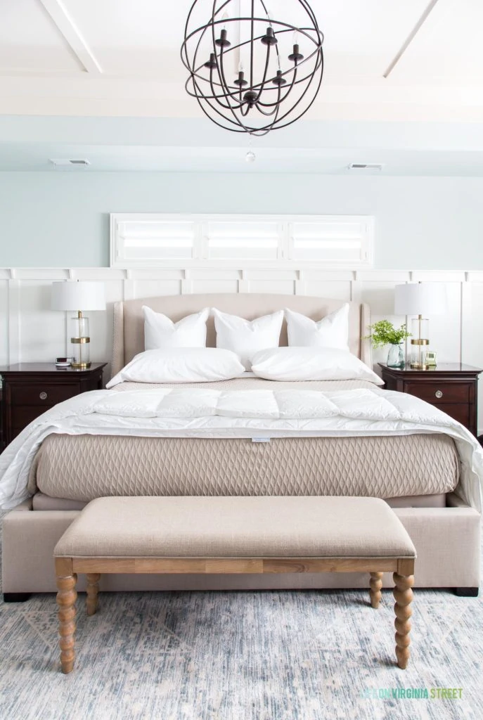 Wood and fabric bench in front of neutral bed.